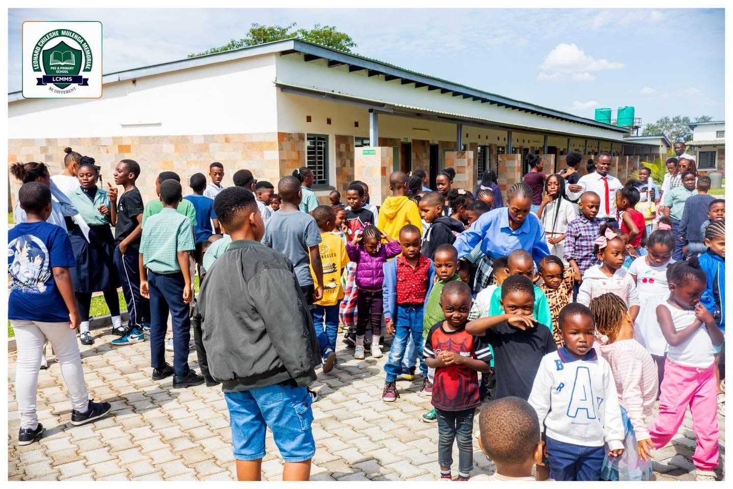 Pupils and families gathered on the paved walkway outside the classrooms