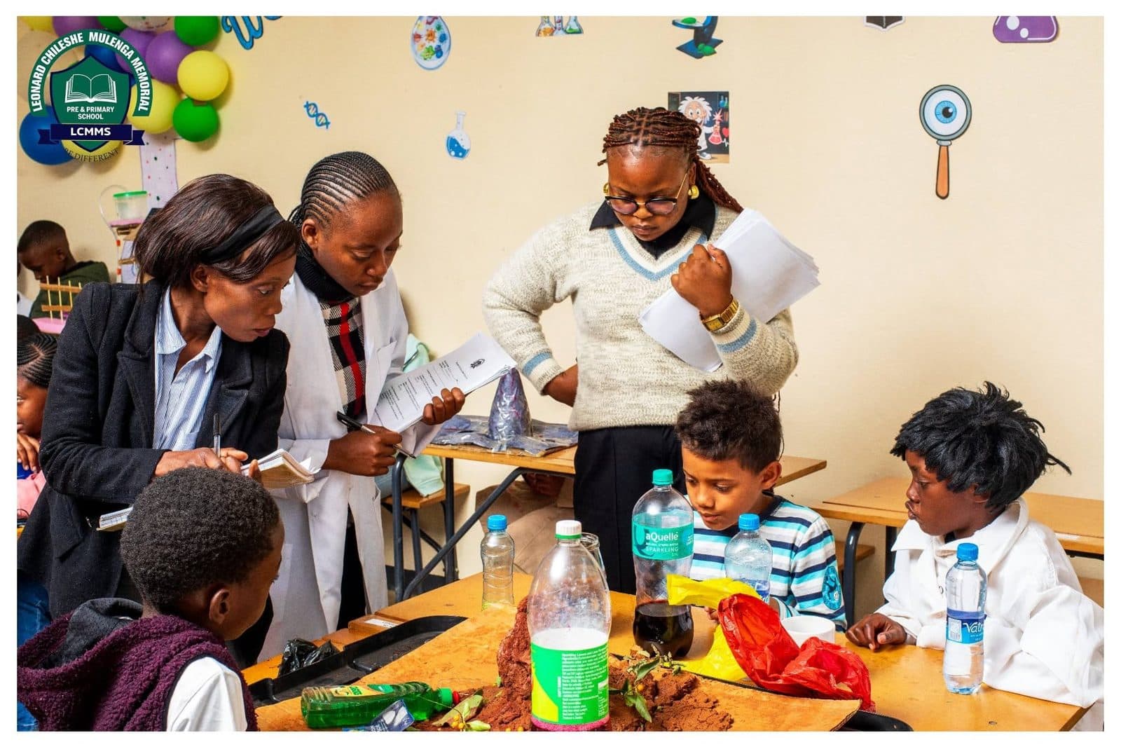 Teachers guiding pupils through a hands-on lesson around a classroom table