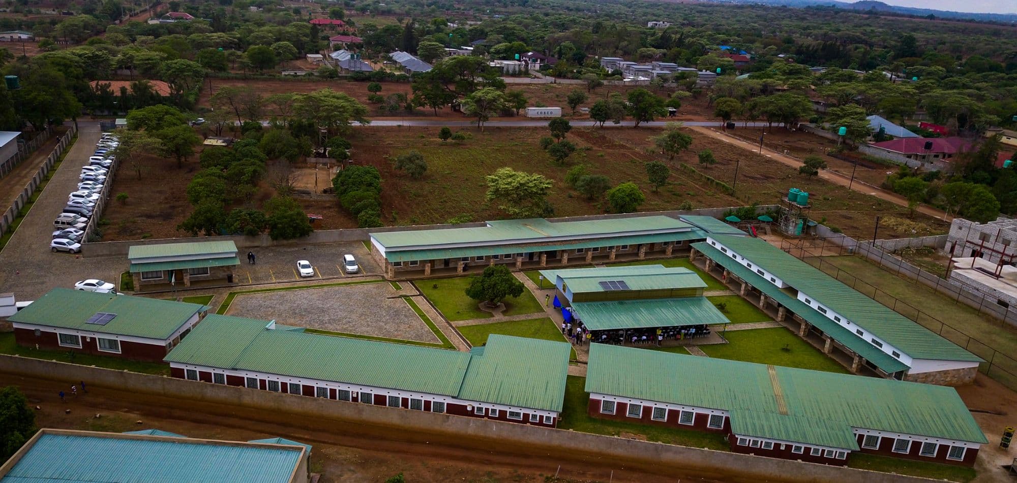 Aerial view of the school campus in Makeni, its green-roofed classroom blocks set around a central courtyard