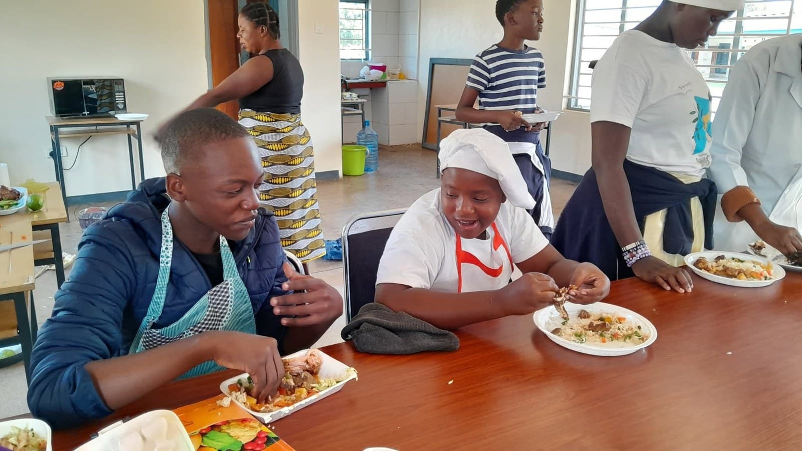 Learners share a meal at a classroom table after the Grade 7 cooking activity
