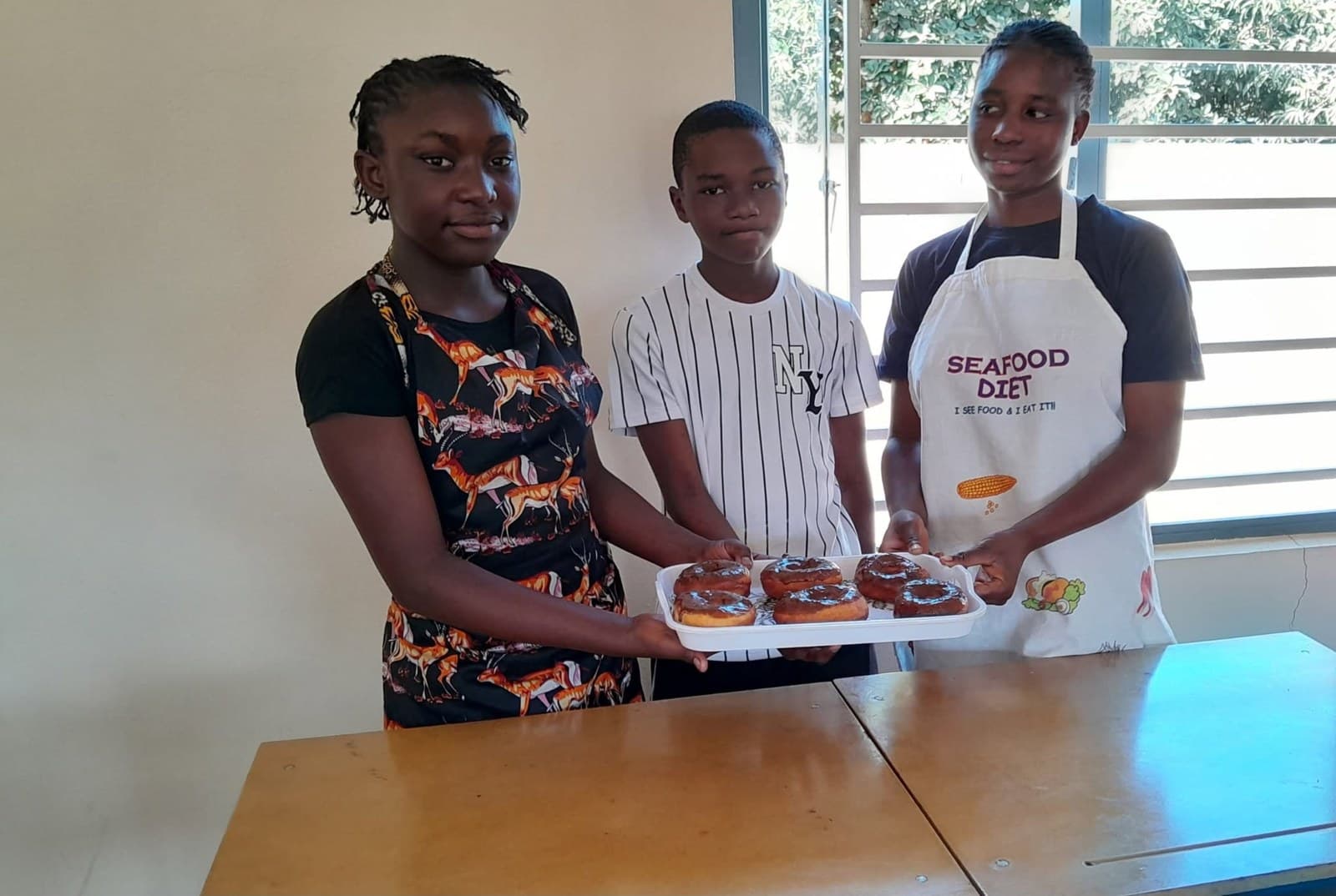 Three learners display a platter of food from their Grade 7 cooking activity