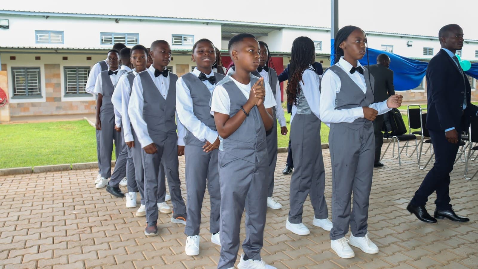 Older learners in school uniform line up together during the graduation celebration