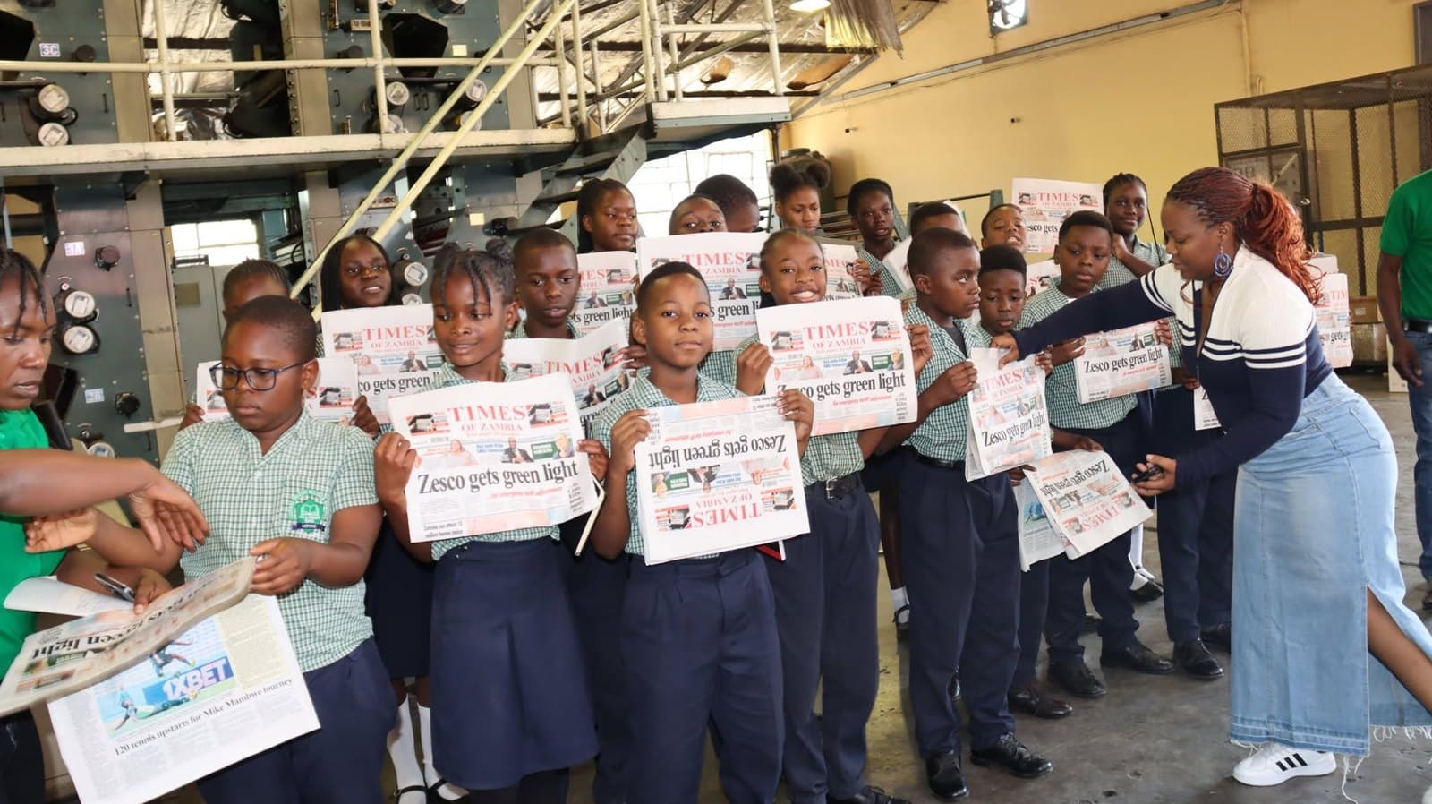 Learners share a cheerful moment holding their newspaper copies during the visit
