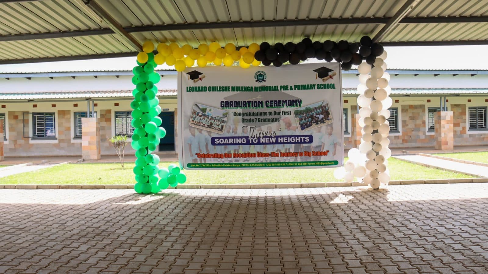 The graduation venue decorated with green, yellow and black balloons and a banner