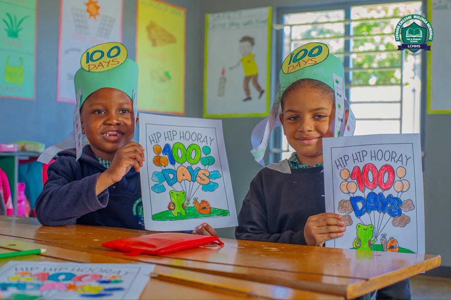 Two pupils holding up their 100 Days of School posters