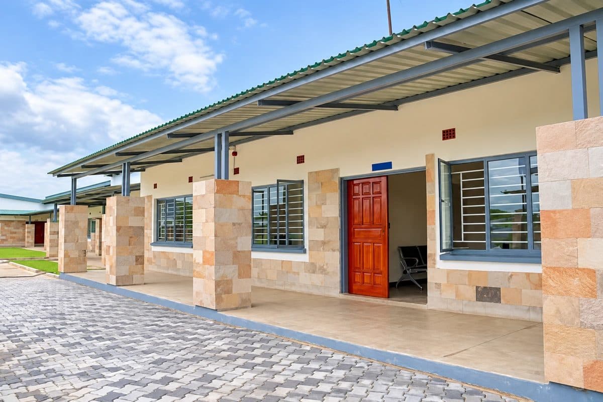 Leonard Chileshe Mulenga Memorial School classroom block with a covered walkway and stone-clad pillars