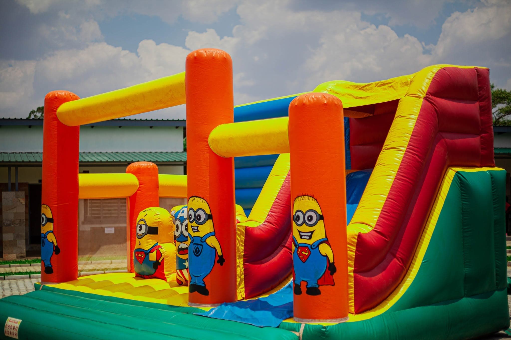Colourful inflatable slide and bouncy castle in the school courtyard