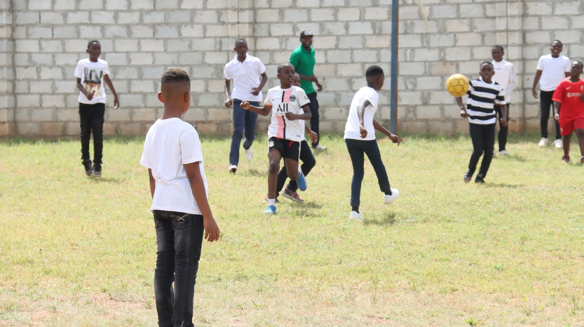 Learners playing football together on the school field