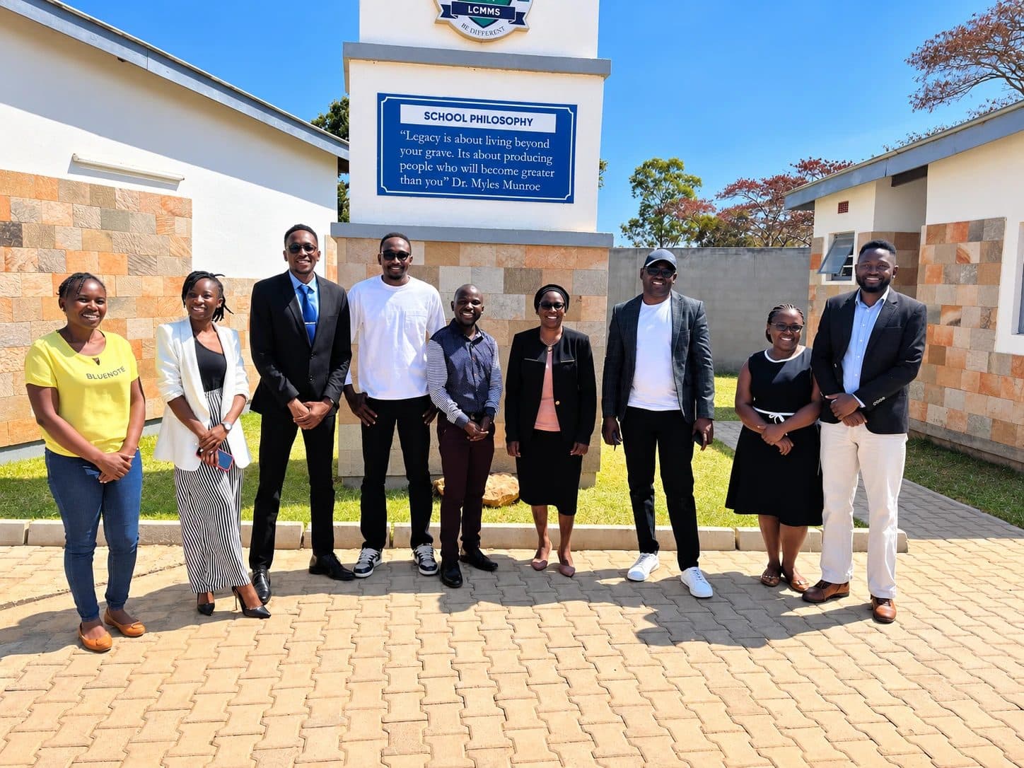 The LCMMS team standing together in front of the school philosophy sign