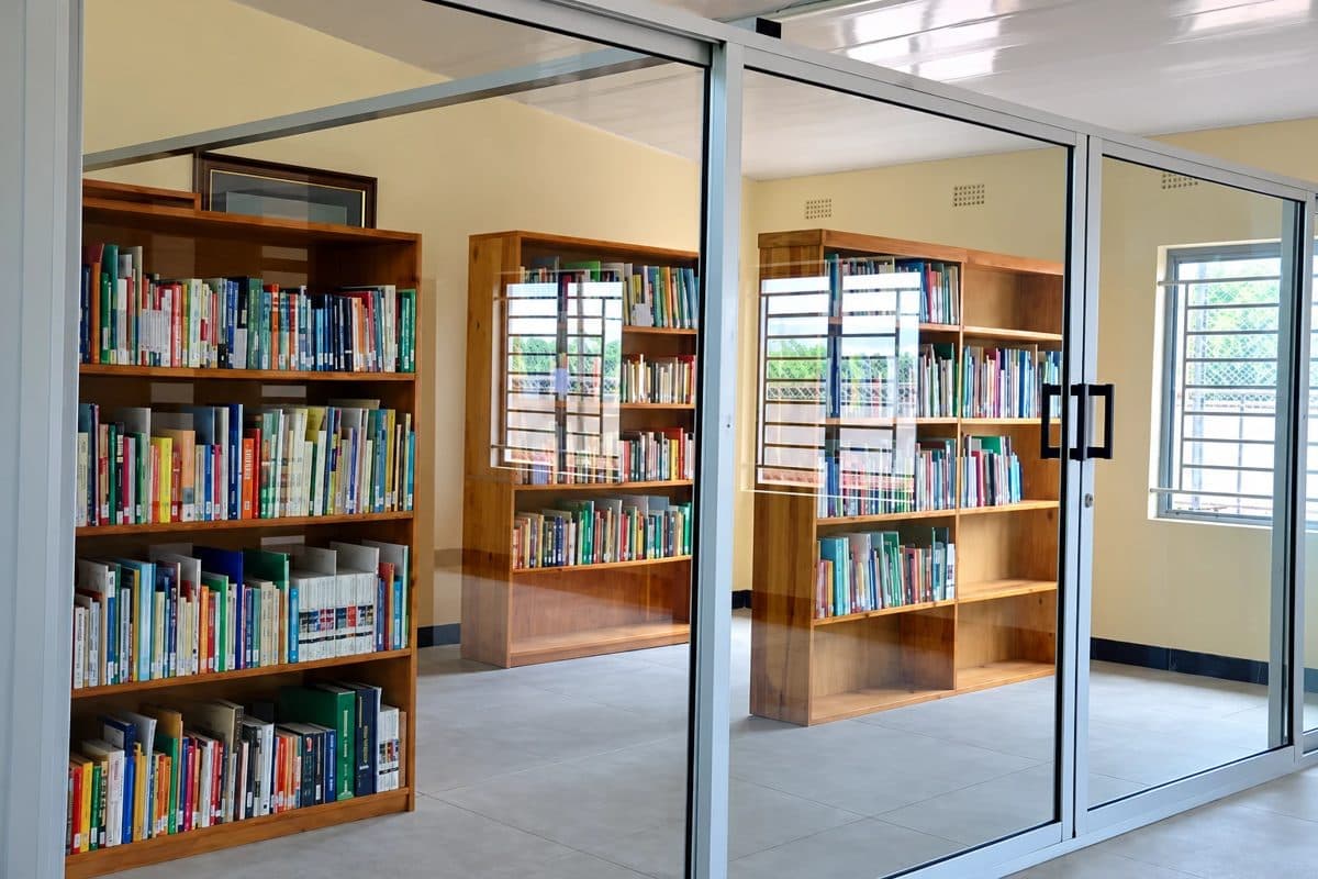 The school library behind glass doors, with wooden shelves full of books
